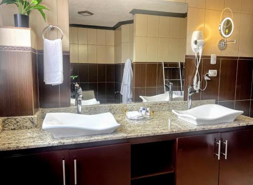a bathroom with two sinks and a large mirror at GyV Executive in Tegucigalpa