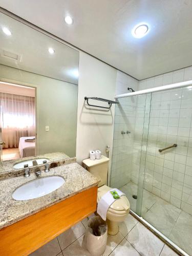 a bathroom with a sink and a shower and a toilet at Bienal First Class Flat Service in São Paulo