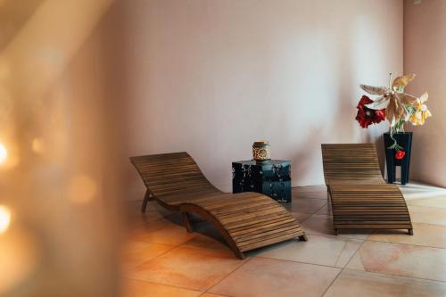 two wooden chairs and a vase with a plant at Villa Liverzano in Brisighella