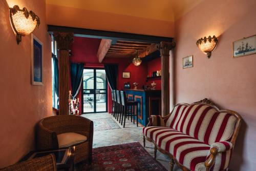 a living room with a couch and chairs and a bar at Villa Liverzano in Brisighella