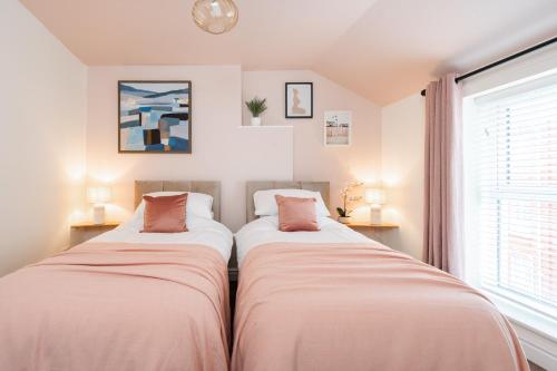 two beds in a room with a window at The Tides, 3 bed house Morecambe in Morecambe