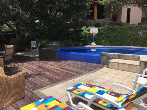 a pool with two lawn chairs and a lounge chair sidx sidx sidx at Beautiful Lake Front House AT001 in Sololá