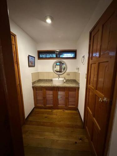 a bathroom with a sink and a mirror at Beautiful Lake Front House AT001 in Sololá
