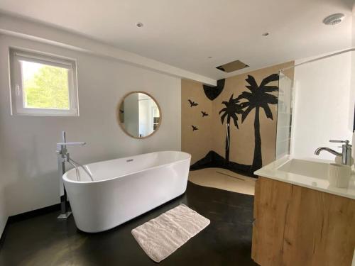 La salle de bains est pourvue d'une grande baignoire blanche et d'un lavabo. dans l'établissement Chalet au calme avec vue, à Viéville