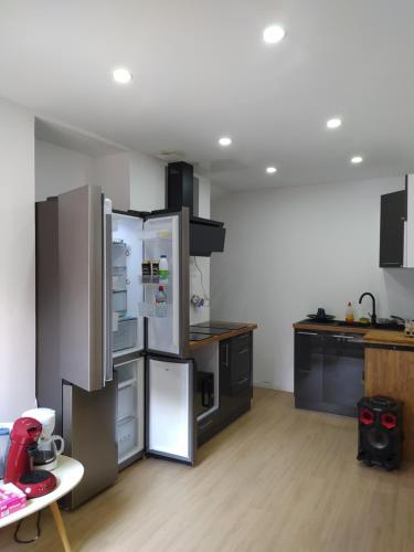 a kitchen with a refrigerator and a table in it at Locatif gare Lille Europe Souvenir in Lille