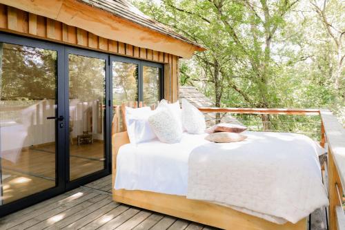 a bed on the deck of a house at Dolce et Cabane in Bérat