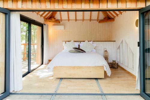a bedroom with a bed and large windows at Dolce et Cabane in Bérat