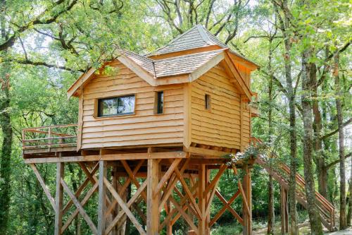 a tree house on a wooden stand in the woods at Dolce et Cabane in Bérat