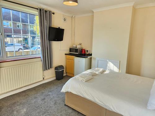 a hotel room with a bed and a window at Central Studios 87 Tennyson Road in Cheltenham