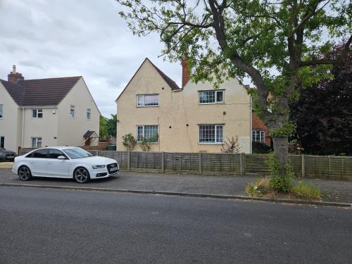 a white car parked in front of a house at Central Studios 87 Tennyson Road in Cheltenham
