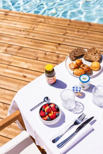 een tafel met eten erop naast een zwembad bij Lou Mare in Saint-Tropez
