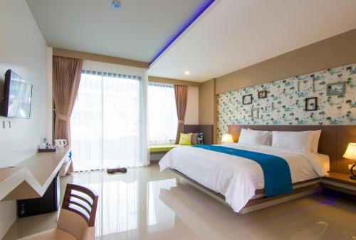 a bedroom with a large bed and a large window at The Phu Beach Hotel - SHA Plus in Ao Nang Beach