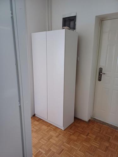 a white refrigerator in a room with a wooden floor at Taki stan in Konjic
