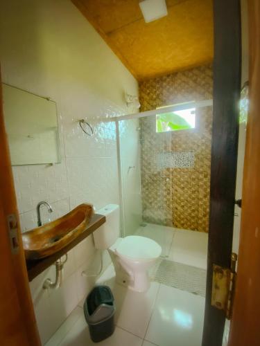 a bathroom with a toilet and a sink and a shower at Flats Vila Bella in Marau