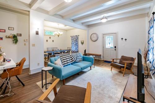 ein Wohnzimmer mit einem blauen Sofa und einem Tisch in der Unterkunft Charming 3BR Historic Home on Mardi Gras Route in Lafayette