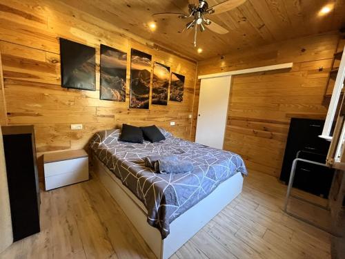 a bedroom with a bed in a wooden wall at La Casita Gergaleña, Confort in Gérgal