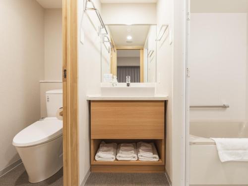 a bathroom with a sink and a toilet at Sotetsu Fresa Inn Hiroshima in Hiroshima