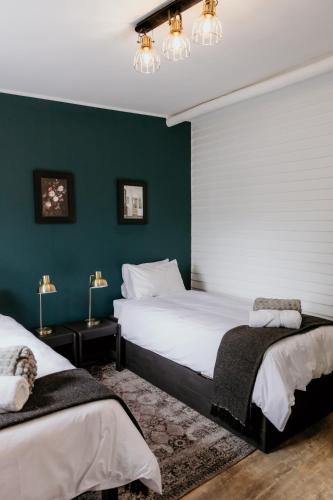 two beds in a bedroom with green walls at Fritz Manor Bed and Breakfast in Swakopmund