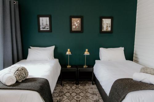 two beds in a room with green walls at Fritz Manor Bed and Breakfast in Swakopmund