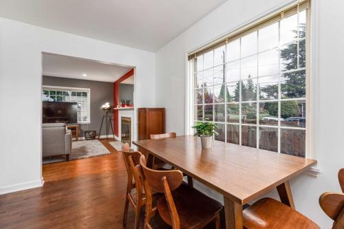 a dining room with a wooden table and a large window at Remodeled Home Fenced Yard Outdoor Fireplace in Seattle