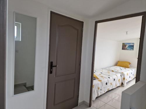 a bedroom with a door leading to a bed at Dodo La FaMi in Sainte-Suzanne