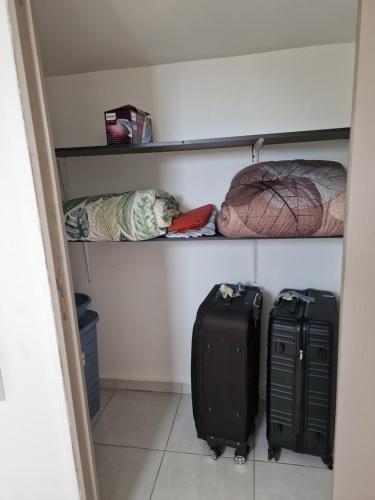 a room with two suitcases and a pillow and aumbledore at Dodo La FaMi in Sainte-Suzanne