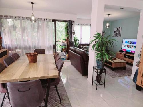 un salon avec une table en bois et un canapé dans l'établissement Magnifique appartement à louer pendant les JO Paris 2024, à Fontenay-le-Fleury