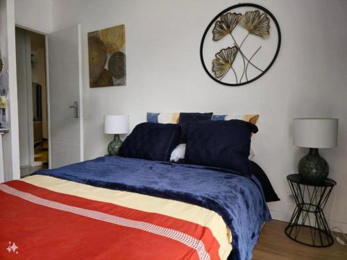 une chambre avec un lit et une horloge au mur dans l'établissement Magnifique appartement à louer pendant les JO Paris 2024, à Fontenay-le-Fleury