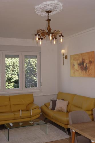 a living room with a couch and a chandelier at Macedonia Square Apartment in Skopje