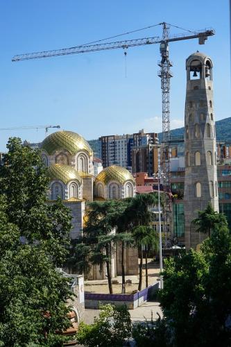 a building with a crane in front of a city at Macedonia Square Apartment in Skopje
