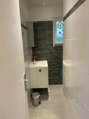 une salle de bain avec un lavabo blanc et une fenêtre dans l'établissement Maison de charme à Savigny-sur-Clairis avec piscine et sauna., à Savigny-sur-Clairis