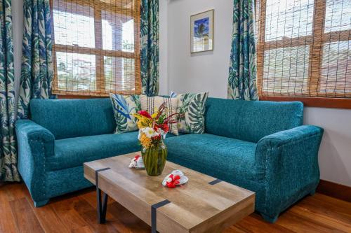 a living room with two blue couches and a coffee table at The Lodge at Jaguar Reef in Hopkins