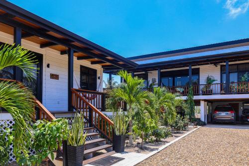 a house with palm trees in front of it at The Lodge at Jaguar Reef in Hopkins