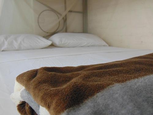 a bed with two pillows and a blanket on it at Dunarinka in Minca
