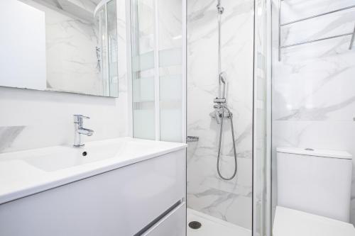 ein weißes Badezimmer mit Dusche und Waschbecken in der Unterkunft Penthouse El Pato 872 Levante Beach in Benidorm