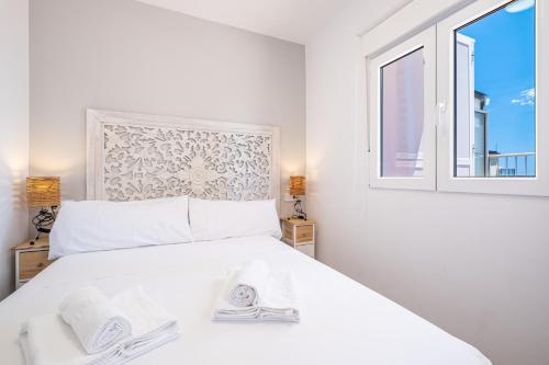 ein weißes Schlafzimmer mit einem Bett und einem Fenster in der Unterkunft Penthouse El Pato 872 Levante Beach in Benidorm