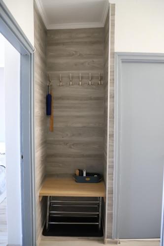 a closet with a wooden bench in a room at Üveghíd Apartman in Sátoraljaújhely
