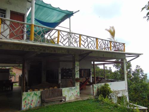 a house with a balcony on top of it at Dunarinka in Minca
