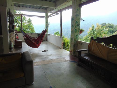 a room with a hammock and a view of the mountains at Dunarinka in Minca