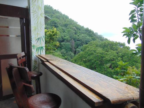 a table and a chair on a balcony with a mountain at Dunarinka in Minca
