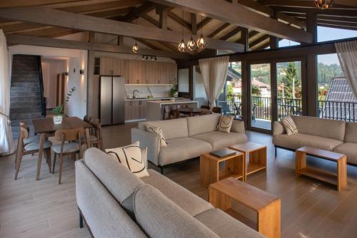 a living room with couches and tables and a kitchen at REY Chalet in Vatra Dornei