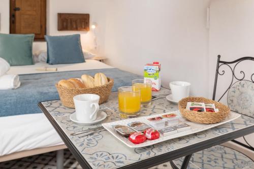 a breakfast table with a tray of food and orange juice at Casa Lunarito in Vejer de la Frontera