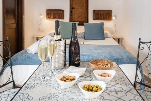 a table with two bottles of champagne and bowls of food at Casa Lunarito in Vejer de la Frontera