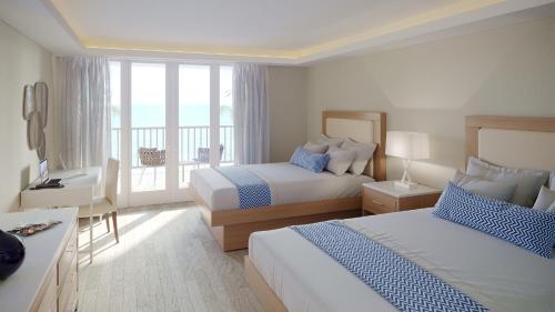 a hotel room with two beds and a balcony at Oceans at Carina Bay - Adults Only in Christiansted