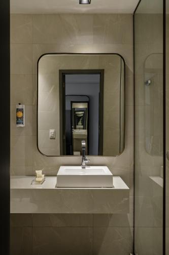 a bathroom with a sink and a mirror at HCM - Hotel Corais de Manaira in João Pessoa