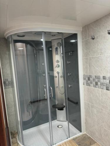 a shower with a glass door in a bathroom at Ceiba Rooms Hotel in Pereira