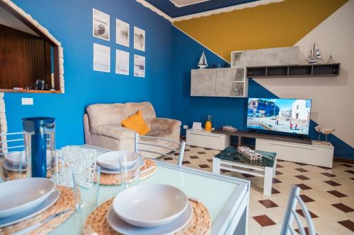 a living room with blue walls and a glass table at Vossia Casa Vacanze in Acquedolci