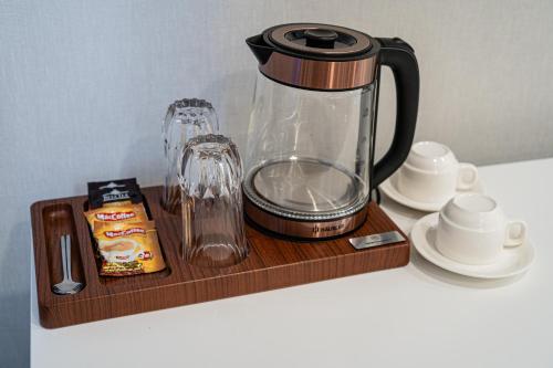 a coffee maker on a wooden shelf with a blender at Makhambet Hotel in Shymkent