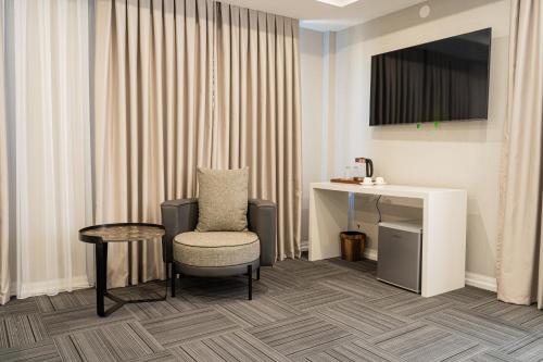 a hotel room with a chair and a desk at Makhambet Hotel in Shymkent