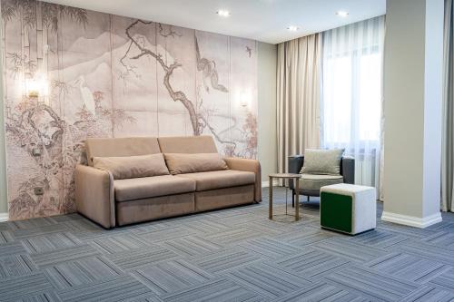 a living room with a couch and a chair at Makhambet Hotel in Shymkent